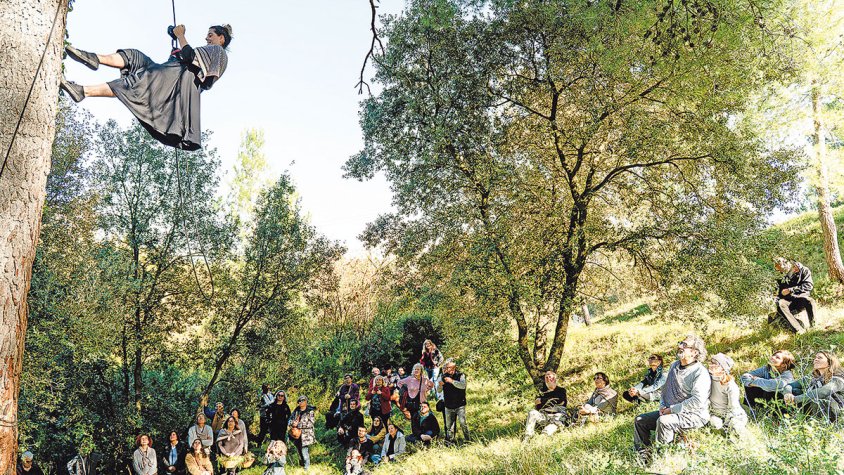 Veïns i veïnes de 'Micropobles a Escena' dansen entre arbres